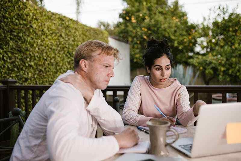un couple l'air inquiet regarde l'écran de leur ordinateur